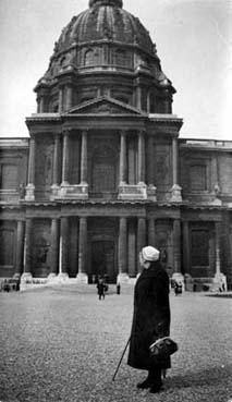 Iconographie - Femme âgée portant la coiffe, posant devant les Invalides à Paris