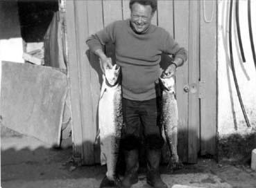 Iconographie - Yves Sachau dit "Meniottes" posant avec sa pêche : deux saumons