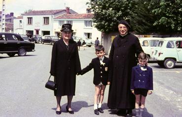 Iconographie - Prêtre posant avec deux enfants et leur grand mère