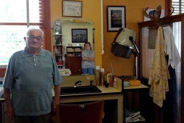 Iconographie - L'ancien artisan coiffeur devant son comptoir