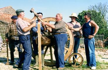 Iconographie - Construction de la brouette géante - Bénévoles autour de la roue