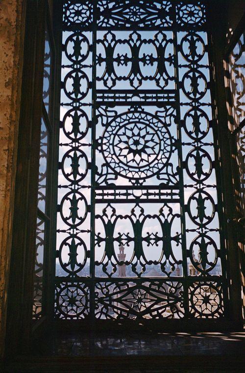Iconographie - Vue sur la mosquée au travers d'une ouverture en fer forgé