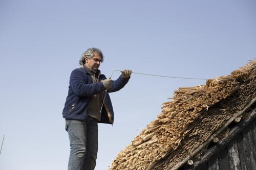 Iconographie - Chaumier travaillant à la réfection de la toiture d'une salorge