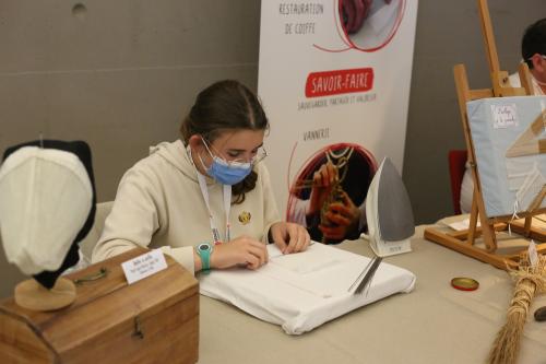 Iconographie - Nanon Blin sur le stand restauration de coiffe lors de la Grande Fête