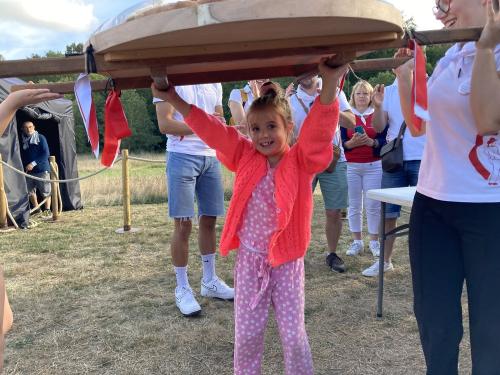 Iconographie - Une petite fille s’essayant au portage de la brioche avec des jeunes des Joyeux Vendéens du Boupère