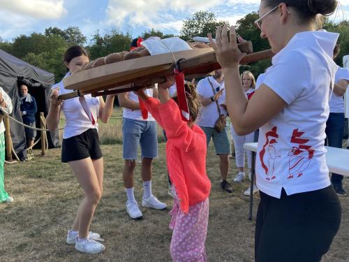 Iconographie - Une petite fille s’essayant au portage de la brioche avec des jeunes des Joyeux Vendéens du Boupère