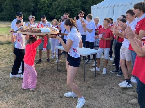 Iconographie - Une petite fille s’essayant au portage de la brioche avec des jeunes des Joyeux Vendéens du Boupère