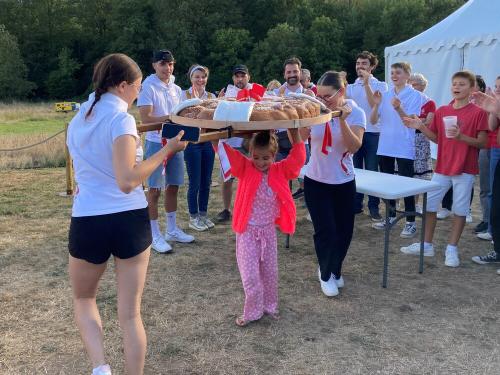 Iconographie - Une petite fille s’essayant au portage de la brioche avec des jeunes des Joyeux Vendéens du Boupère