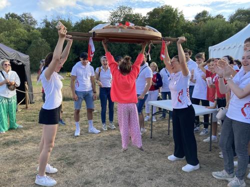 Iconographie - Une petite fille s’essayant au portage de la brioche avec des jeunes des Joyeux Vendéens du Boupère