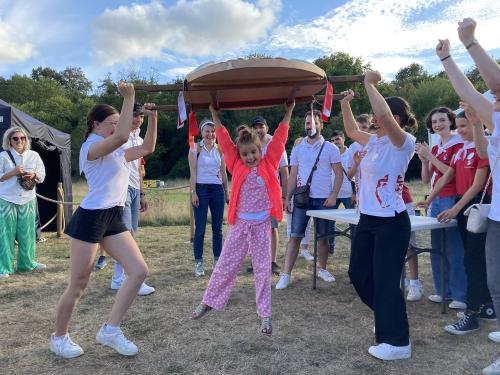 Iconographie - Une petite fille s’essayant au portage de la brioche avec des jeunes des Joyeux Vendéens du Boupère